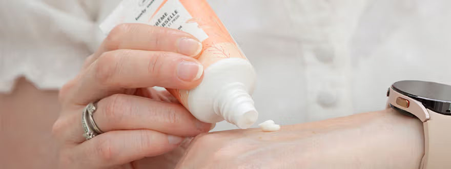 Une femme qui s'applique la crème universelle sur ses mains