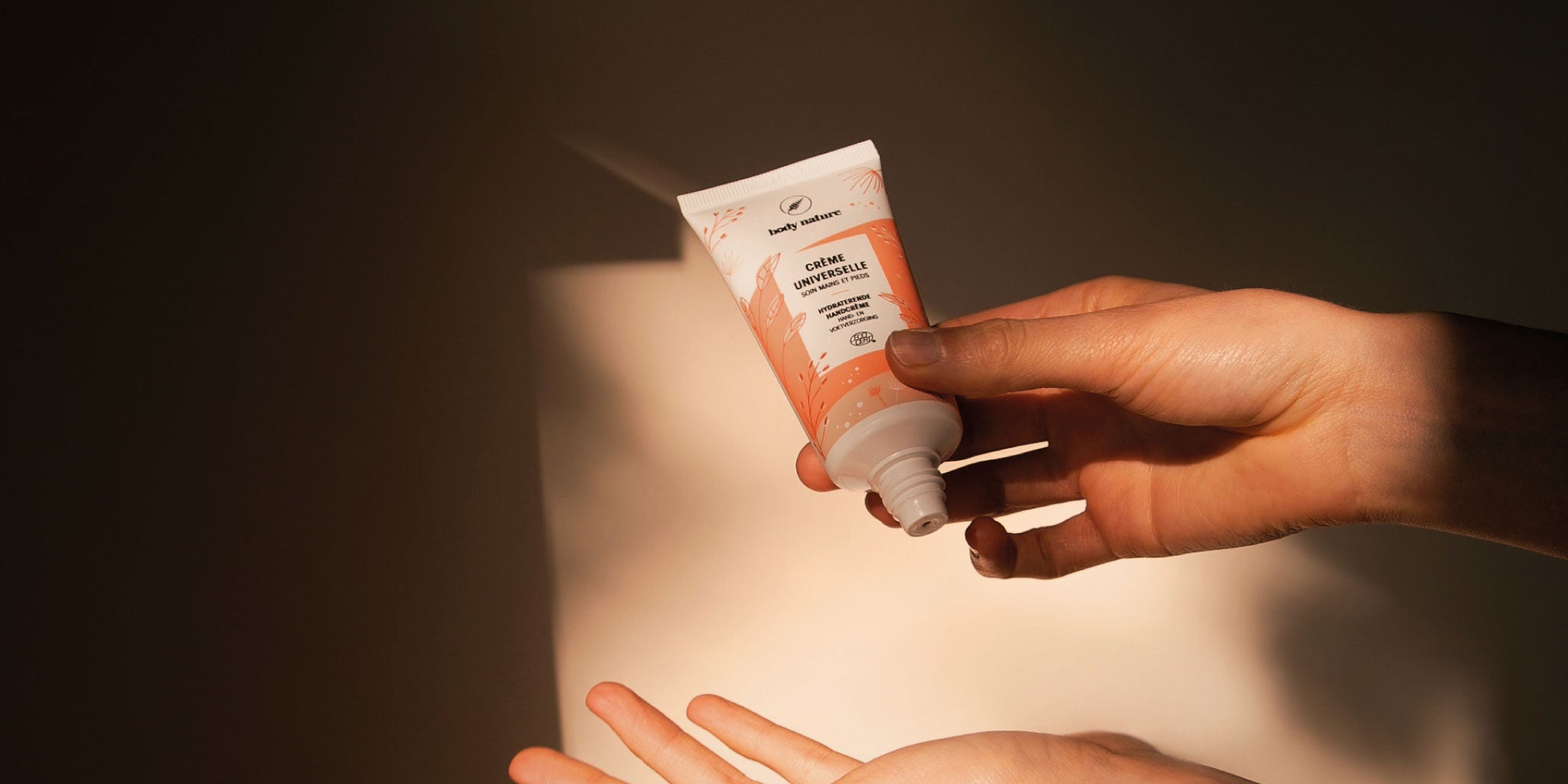 Une femme met de la crème universelle sur sa main